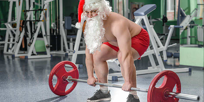 Santa Claus lifting weights in the gym