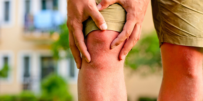 person with knee pain holding