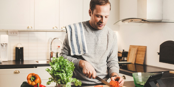 Man cutting fruits and vegetables for dinner organize kitchen for weight loss